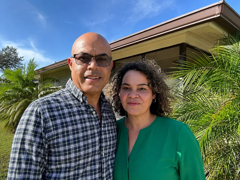 Samuel and Odalis Benitez standing together outside their home in Puerto Rico