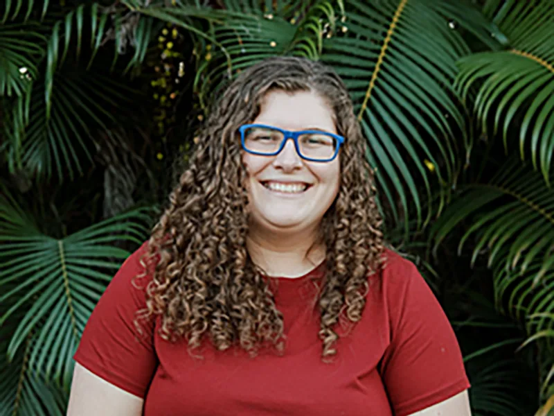 Carys Stogdill smiling in front of palm fronds