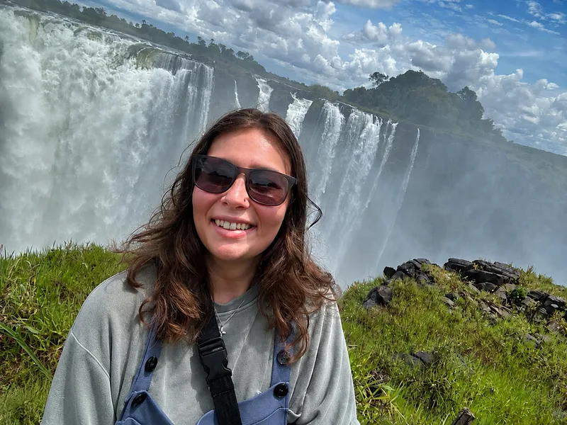 Hannah Beckley smiling in front of Victoria Falls