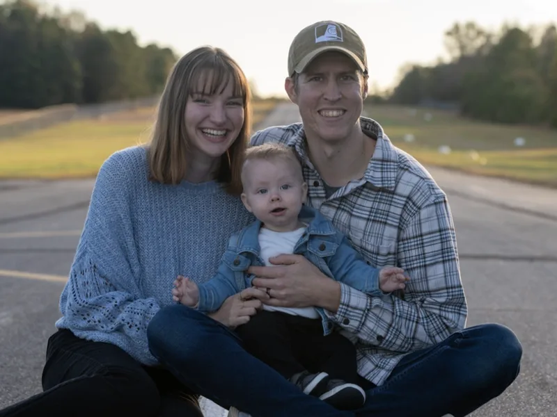 Phillip and Anna Mull sitting outside with their young child